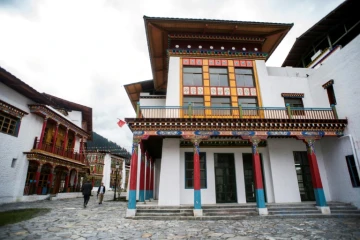 Des journalistes passent devant des logements vides, le 13 septembre 2016 à Lulang, dans la région chinoise autonome du Tibet  