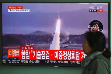 Une femme passe devant un écran de télévision montrant un nouveau tir de missile en Corée du nord, le 5 avril 2017 à Séoul