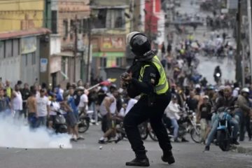 Un policier anti-émeutes tire du gaz lacrymogène contre des manifestants opposés au président Nicolas Maduro, dans le quartier de Catia à Caracas le 29 juillet 2024 ( AFP / Yuri CORTEZ )