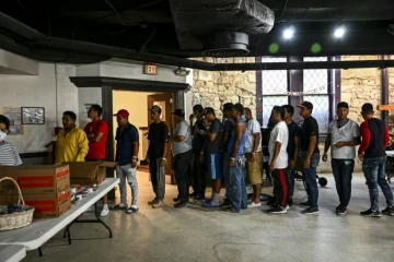 Des migrants font la queue pour une distribution de repas dans un refuge à San Antonio, le 29 juin 2022 au Texas
