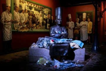 Des fleurs déposées au pied de la statue de Paul Bocuse dans sa célèbre auberge de Collonges-au-Mont-d'Or, dans le Rhône, le 20 janvier 2018