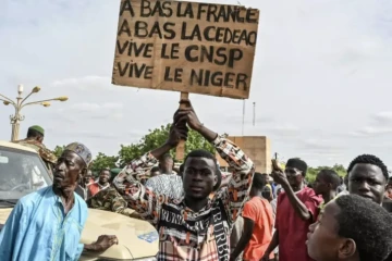 Un partisan du Conseil national pour la sauvegarde de la patrie (CNSP) du Niger tient une pancarte lors d'une manifestation devant le Stade Général Seyni Kountche à Niamey, au Niger, le 6 août 2023 ( AFP / - )