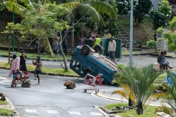 Un habitant dégage une route à Nouméa, le 15 mai 2024