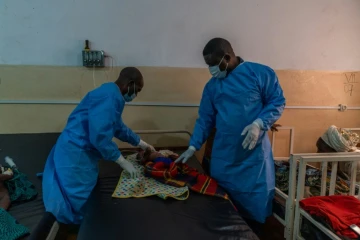 Le Dr Robert Musole (à droite), directeur médical de l'hôpital de Kavumu, en République démocratique du Congo, ausculte un nourrisson atteint d'une forme grave de mpox, le 24 août 2024