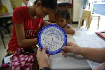 Une Philippine remplit un formulaire le 10 octobre  2017 pour obtenir des pilules contraceptives dans un établissement géré par une ONG dans un bidonville de Manille
