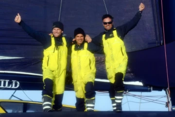 Franck Cammas (g) et Charles Caudrelier (d) avec leur "Media Man" Yann Riou à bord de leur Maxi Edmond de Rothschild à l'arrivée de la Brest Altantiques, le 4 décembre 2019 à Brest  