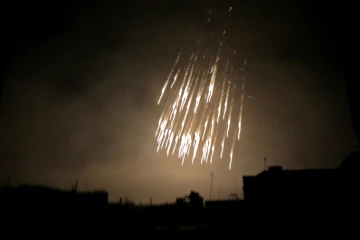 Photo prise le 23 mars 2018 montrant ce qui semble être des engins incendiaires au phosphore blanc tombant sur la ville de Douma, dans une des dernières poches rebelles de la Ghouta orientale, à l'est de Damas