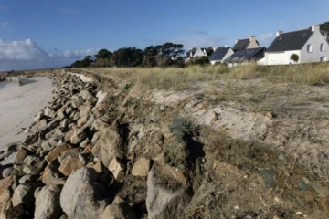 La dune érodée et les maisons en arrière-plan menacées par la submersion marine et l'érosion à Treffiagat, dans le Finistère, le 19 décembre 2024 ( AFP / FRED TANNEAU )