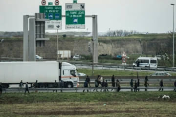 Des migrants marchent sur l'autoroute A16, le 3 décembre 2015 à Coquelles, dans le Pas-de-Calais