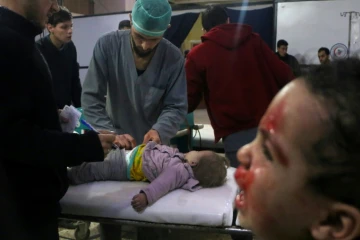 Des médecins syriens examinent une enfant dans un hôpital de fortune après des bombardements du régime syrien sur la ville de Douma dans la Ghouta orientale, le 22 février 2018