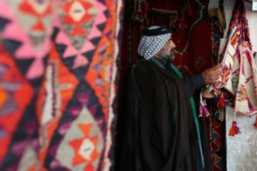 Le cheikh Hazem al-Hiyali regarde des tapis traditionnels dans une échoppe du marché des tapis, le 12 octobre 2017 à Hilla, en Irak