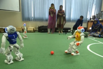 Des étudiants pakistanais membres de l'équipe de robotique observent leurs robots en plein match à l'université de sciences et de technologie d'Islamabad, le 9 mai 2016