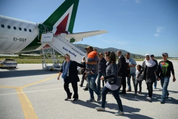 Des familles de réfugiés syriens embarquent à bord de l'avion du pape le 16 avril 2016 à l'aéroport de Mytilène 
