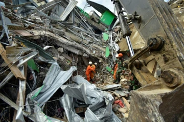 Des secours indonésiens sur le site d'un bâtiment effondré à Mamuju, le 16 janvier 2021, après un séisme de magnitude 6,2 qui a frappé l'île de Célèbres
