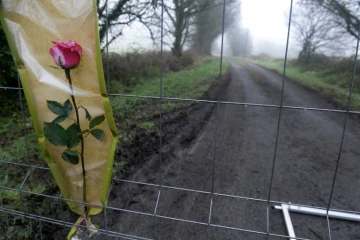 Une rose attachée à une grille fermant l'accès de la ferme Hubert Caouissi, soupçonné de l'assassinat de la famille Troadec, à Pont-de-Buis (sud-ouest) le 10 mars 2017
