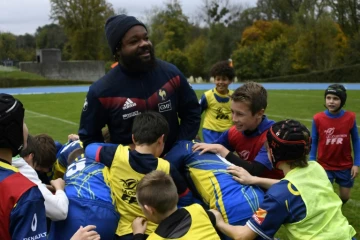 Le centre du XV de France Mathieu Bastareaud entouré d'enfants d'un club de rugby au centre d'entraînement de Marcoussis, le 4 novembre 2017 