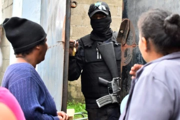 Des parents de détenus demandent des nouvelles de leurs proches à un policier devant la prison de Tela après des affrontements meurtriers, le 21 décembre 2019