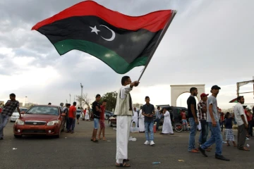 Un homme agite le drapeau libyen, le 7 août 2015 à Benghazi