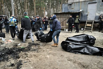 Des employés municipaux transportent six corps partiellement brûlés retrouvés à Boutcha (Ukraine), le 5 avril 2022