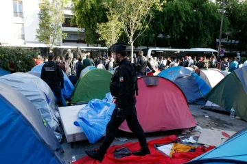 Des gendarmes mènent l'évacuation d'un campement de migrants à la hall Pajol, le 29 juin 2016 à Paris