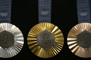 Combinaison de photos prises le 30 janvier 2024 à Paris montrant les médailles (argent, or et bronze, de gauche à droite) des prochains Jeux olympiques de Paris 2024 conçues par la maison française de joaillerie de luxe Chaumet et révélées au public le 8 février 2024.