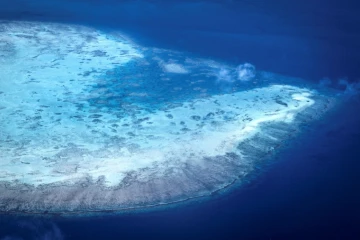 Vue aérienne prise le 4 avril 2024 d'un atoll de corail près de l'île Lizard sur la Grande barrière de corail, à 270 km au nord de Cairns, en Australie