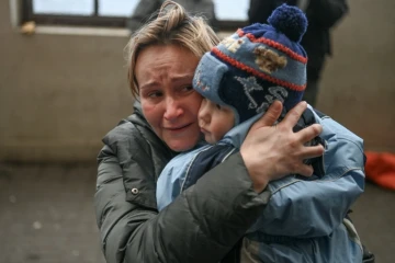 Une femme serre son enfant alors qu'elle tente de monter à bord d'un train au départ de Lviv, dans l'ouest de l'Ukraine, en direction de la Pologne, le 3 mars 2022