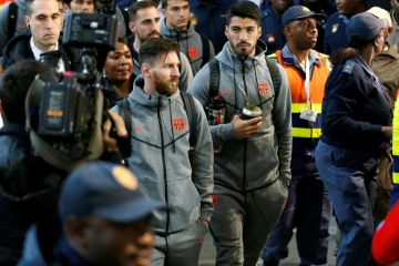 Les joueurs du FC Barcelone Lionel Messi (G) et Luis Suarez (D) arrivent à l'aéroport de Johannesburg, le 16 mai 2018