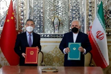 Le ministre iranien des Affaires étrangères Javad Zarif (d) et son homologue chinois Wang Yi après la signature d'un accord de coopération stratégique et commercial, le 27 mars 2021 à Téhéran