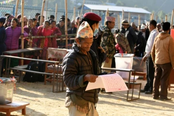 Un Népalais examine les bulletins avant de voter, le 26 novembre 2017, à Chautara, dans le district de Sindhupalchowk