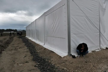 Un homme assis devant une tente d'un camp de migrants près de la  frontière entre la Grèce et la Macédoine à Idomeni, le 14 octobre 2015 