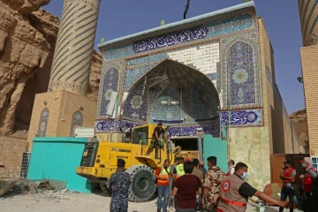 Des équipes de secours recherchent des survivants dans les décombres d'un sanctuaire chiite, le 21 août 2022 à Kerbala, en Irak
