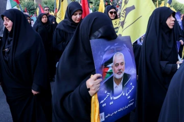Une femme porte un portrait d'Ismaïl Haniyeh, lors d'une manifestation pour dénoncer sa mort, le 31 juillet 2024 sur la place de la Palestine à Téhéran