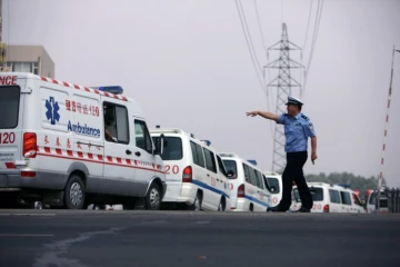 Un policier chinois indique le chemin à des ambulances à Dehui, le 3 juin 2013