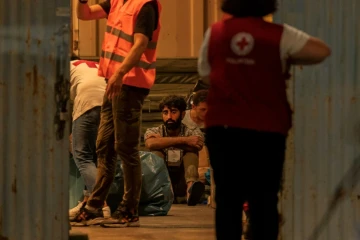 Des migrants, rescapés d'un naufrage, attendent dans le port de Kalamata, le 14 juin 2023 en Grèce