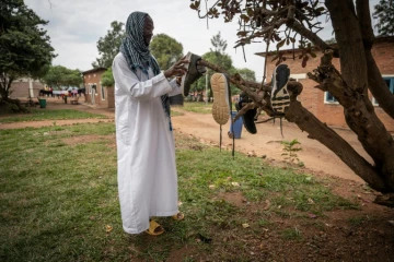 Le Sud-Soudanais Ismail Hmdan Banaga fait sécher ses chaussures au centre de transit de Gashora, le 10 juin 2022