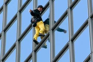 Le "Spiderman français", Alain Robert, escalade à mains nues la tour Total du quartier d'affaires de la Défense, le 21 mars 2016