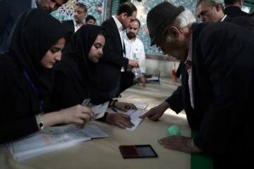 Un Iranien se fait enregistrer pour voter à la présidentielle, le 19 mai 2017 dans un bureau de vote à Téhéran