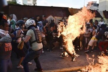 Des manifestants de l'opposition mettent le feu à un voleur présumé pendant une manifestation contre Maduro à Caracas le 20 mai 2017