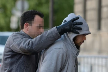 Alexandre Dhaussy, qui a poignardé un militaire à la Défense, escorté par un policier le 29 mai 2013 à Paris