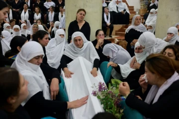 Des femmes druzes se recueillent près d'un cercueil lors des funérailles d'une personne tuée par un tir de roquette en provenance du Liban la veille, à Majdal Shams sur le plateau du Golan annexé par Israël, le 28 juillet 2024