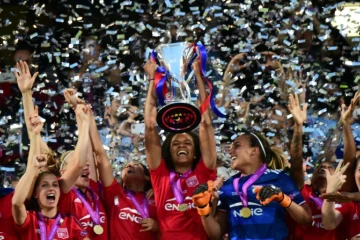 La capitaine de l'Olympique de Lyon Wendie Renard brandit le trophée après la victoire face à Wolfsburg en finale de Ligue des champions, le 26 mai 2016 à Reggio Emilia (Italie)