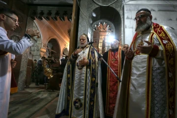 Des prêtres conduisent un office pour des chrétiens d'Irak dans une église à Bartalla, près de Mossoul le 24 décembre 2016 