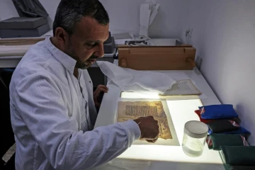 Rami Salameh, un restaurateur palestinien, travaille sur un manuscrit dans un laboratoire de la bibliothèque Khalidi à Jérusalem-Est, le 17 juin 2023