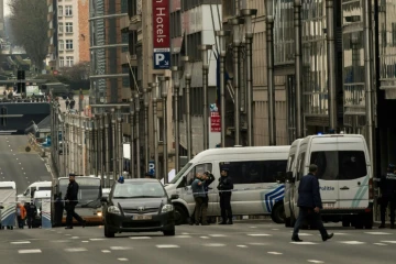 Des policiers montent la garde près d'un périmètre de sécurité rue de la loi près de la station de métro Maalbeek le 21 mars 2016