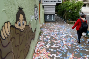 Une femme marche parmi les tracts de candidats aux municipales brésiliennes, le 6 octobre 2024, à Sao Paulo