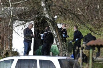 Des gendarmes et des experts en médecine légale fouillent une cabane de jardin le long d'une route près de Domessin dans l'est de la Savoie le 14 février 2018