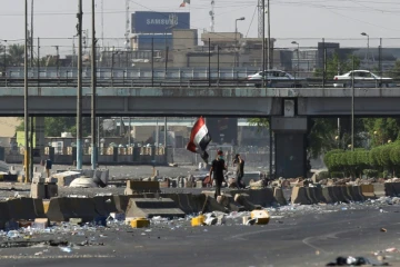 Un drapeau irakien est brandi lors d'une manifestation contre le pouvoir à Bagdad, le 4 octobre 2019