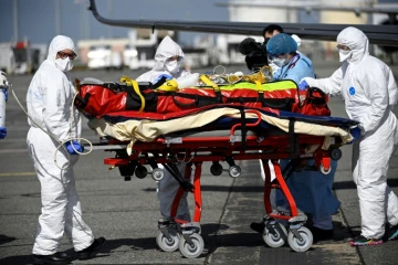 Le personnel médical transporte un patient infecté par le Covid-19 qui a été transféré de Nice, où les unités de soins intensifs sont surchargées, le 16 mars 2021 à Toulouse-Blagnac