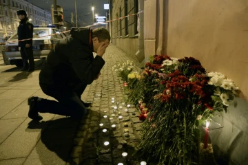 Un homme se recueille après avoir déposé des fleurs en mémoire aux victimes d'un attentat dans le métro, le 3 avril 2017 à Saint-Pétersbourg